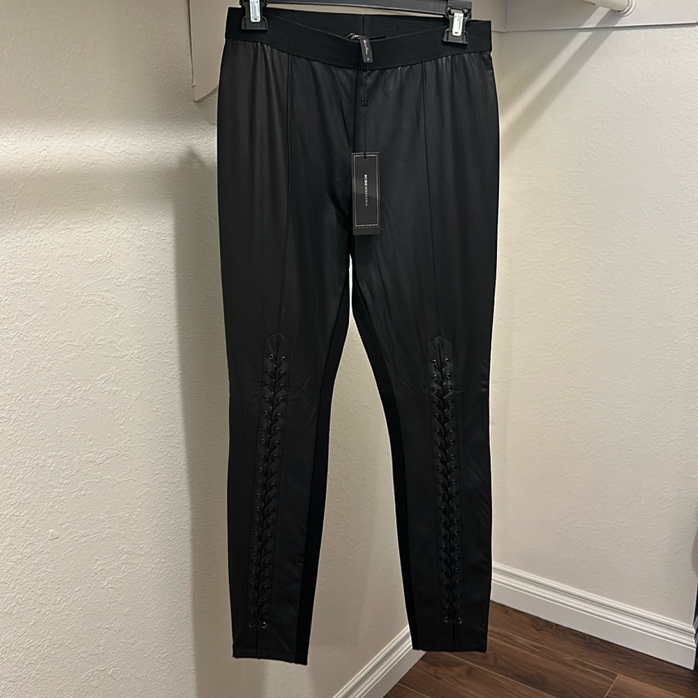 Black fake leather leggings fabric back. Lace up detail